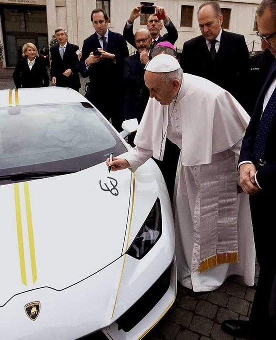 le pape en train de dessiner une obscénité sur le capot d'une voiture